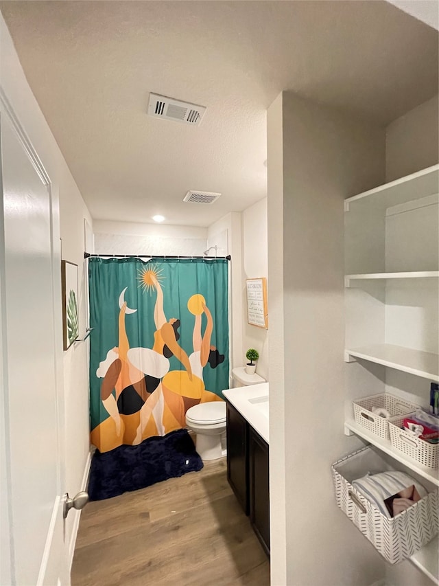 bathroom featuring curtained shower, hardwood / wood-style floors, vanity, and toilet