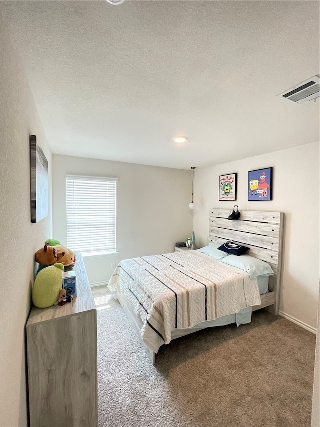 bedroom with a textured ceiling and carpet flooring