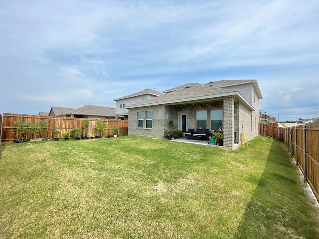 rear view of house featuring a yard and a patio area