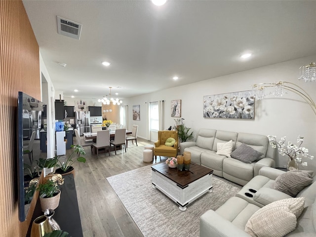 living room with an inviting chandelier and light hardwood / wood-style floors