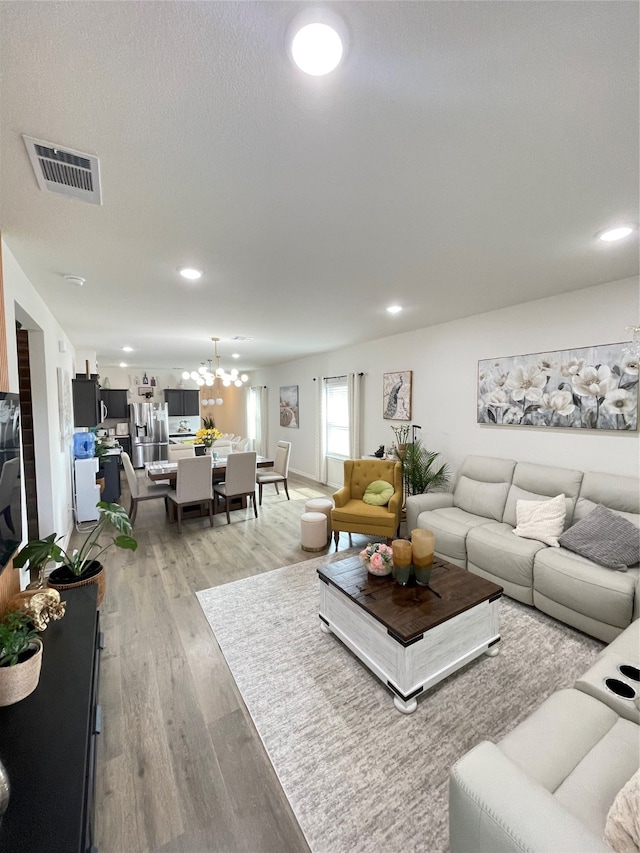 living room featuring an inviting chandelier and light hardwood / wood-style floors