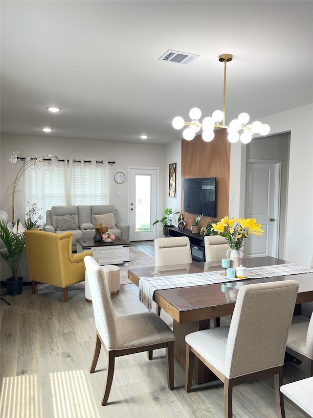 dining space with a chandelier and light hardwood / wood-style flooring