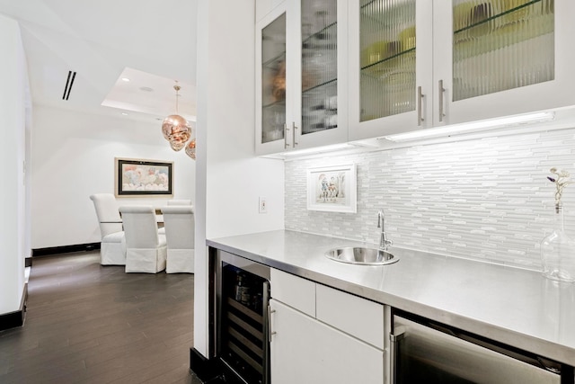 bar featuring white cabinets, a tray ceiling, beverage cooler, and tasteful backsplash