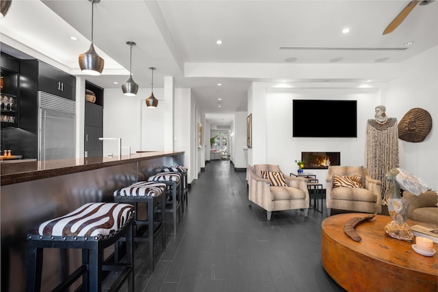 living room featuring ceiling fan and dark hardwood / wood-style floors