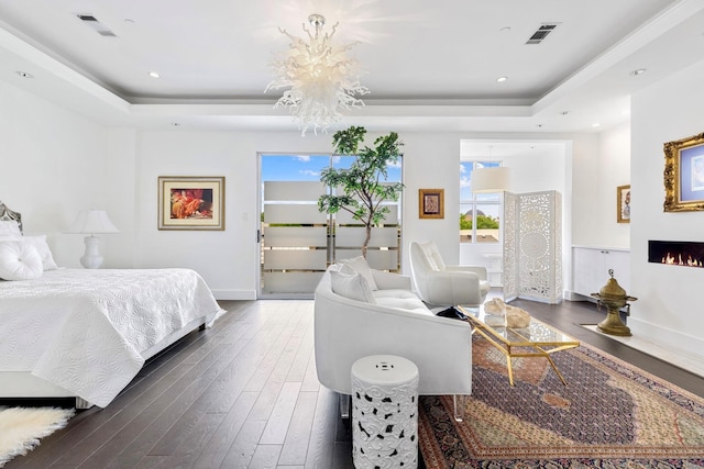 bedroom with a tray ceiling and dark hardwood / wood-style flooring