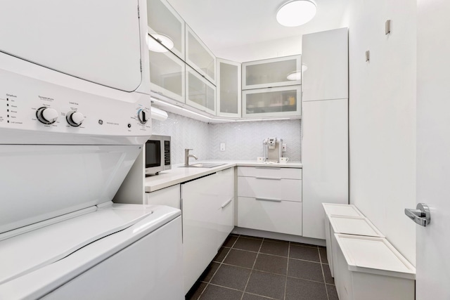 kitchen with stacked washer and dryer and white cabinets