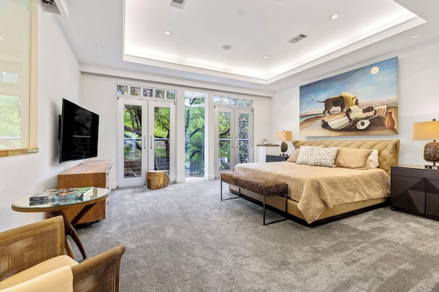 bedroom featuring multiple windows, access to outside, french doors, and a raised ceiling