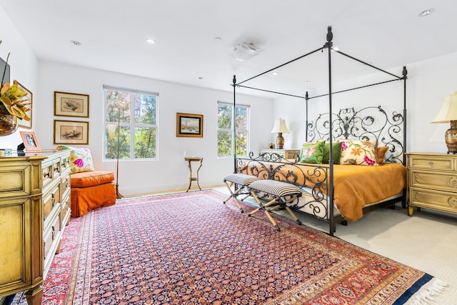 bedroom with light colored carpet and multiple windows