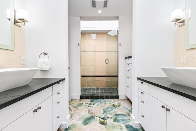 bathroom with tile patterned floors, a shower with door, and vanity