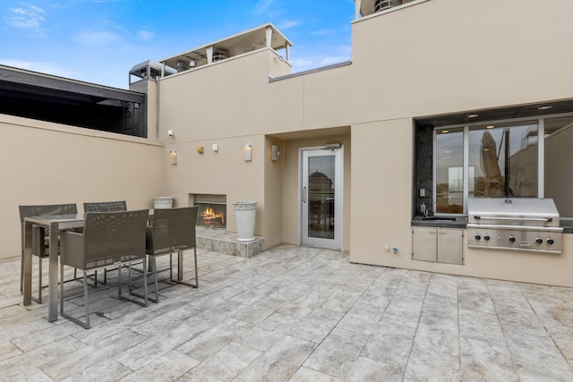 view of patio / terrace featuring an outdoor wet bar, area for grilling, and a grill