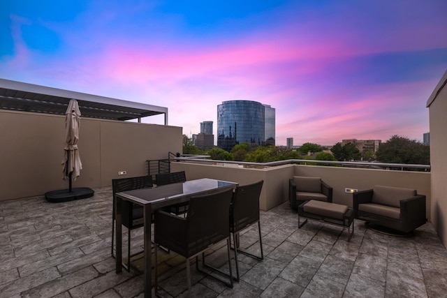 patio terrace at dusk with outdoor lounge area and a pergola