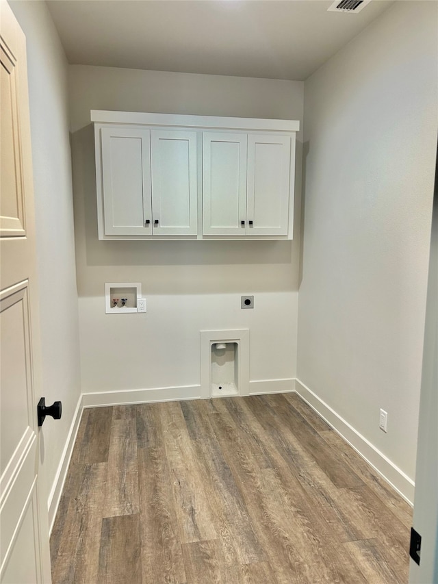 laundry area featuring hookup for a washing machine, light hardwood / wood-style floors, hookup for an electric dryer, and cabinets