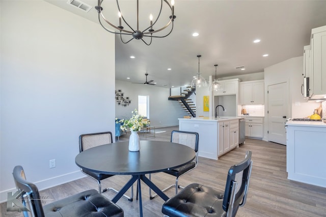 dining space with visible vents, baseboards, light wood-style flooring, stairs, and recessed lighting