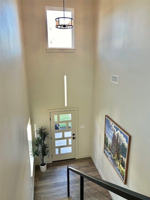 entryway featuring a towering ceiling and dark hardwood / wood-style floors