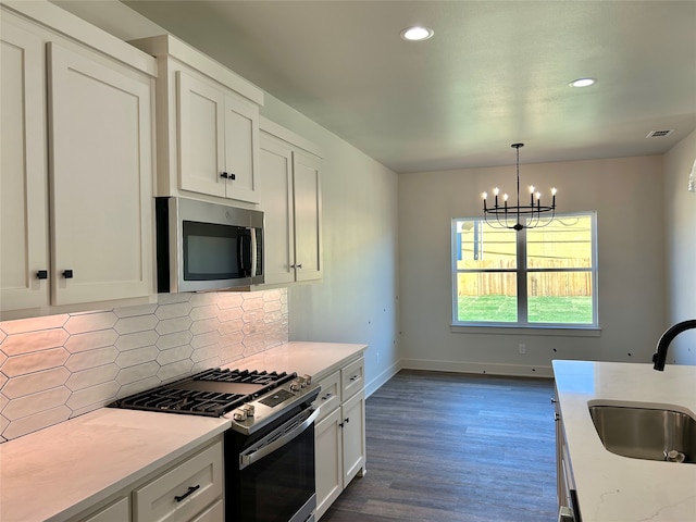 kitchen featuring dark wood-type flooring, sink, white cabinetry, decorative backsplash, and appliances with stainless steel finishes