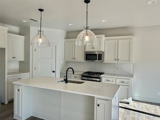 kitchen featuring hanging light fixtures, an island with sink, sink, and stainless steel appliances