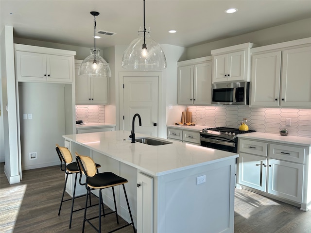 kitchen featuring white cabinetry, a center island with sink, and appliances with stainless steel finishes