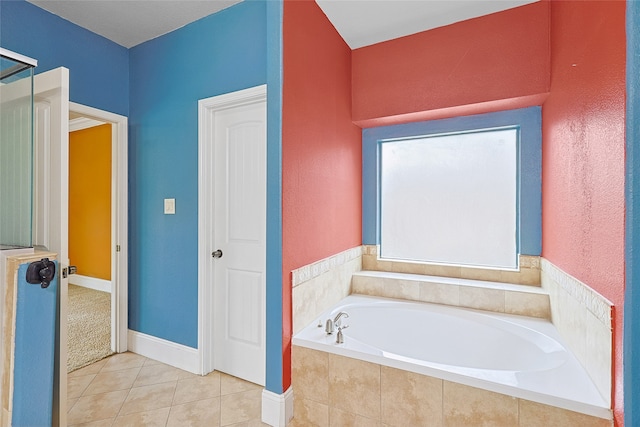 bathroom with tile patterned flooring and a relaxing tiled tub