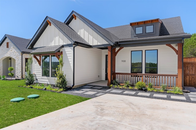 modern farmhouse style home featuring a porch and a front yard