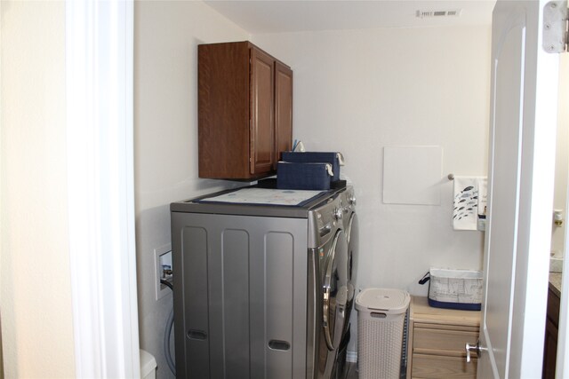 laundry area featuring cabinets and washer and clothes dryer