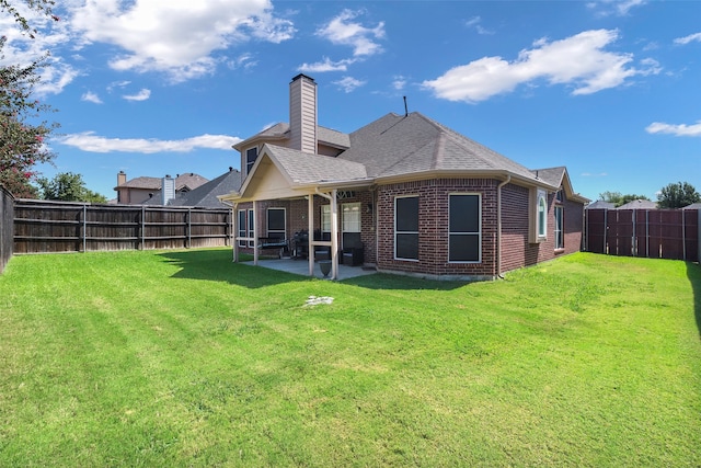 rear view of house featuring a lawn and a patio area