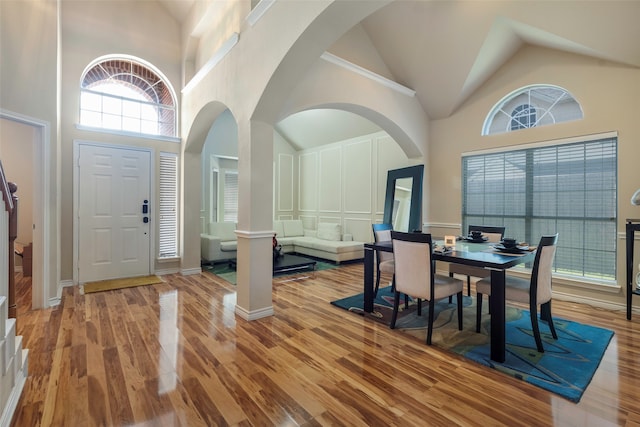 foyer with high vaulted ceiling and hardwood / wood-style floors