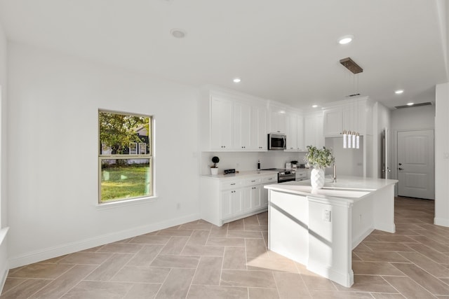 kitchen with white cabinetry, a kitchen island with sink, stainless steel appliances, and decorative light fixtures