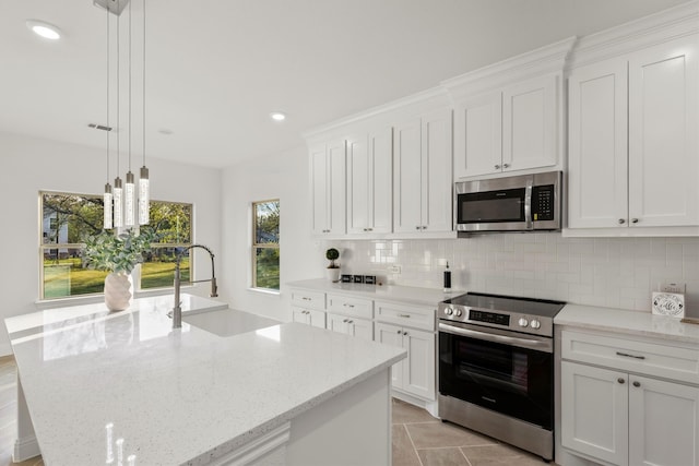 kitchen with appliances with stainless steel finishes, white cabinetry, a healthy amount of sunlight, and hanging light fixtures