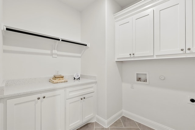 laundry area with hookup for a gas dryer, electric dryer hookup, hookup for a washing machine, light tile patterned floors, and cabinets