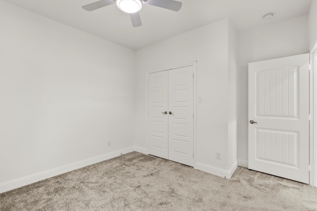 unfurnished bedroom featuring a closet, ceiling fan, and light carpet