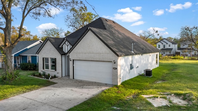 view of front of house featuring a front yard, central AC unit, and a garage