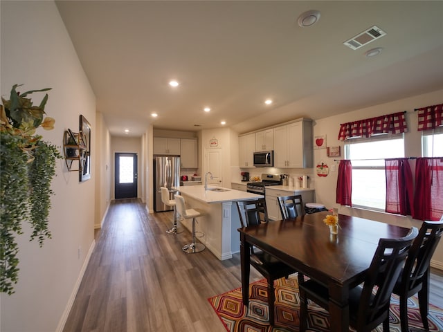 dining room featuring wood-type flooring and sink