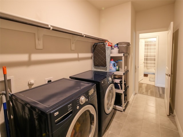 washroom featuring washer and clothes dryer and light tile patterned flooring