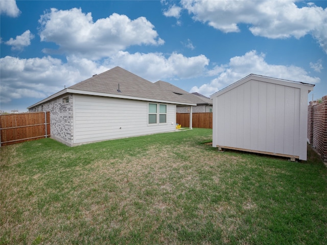 rear view of house with a lawn and a storage unit