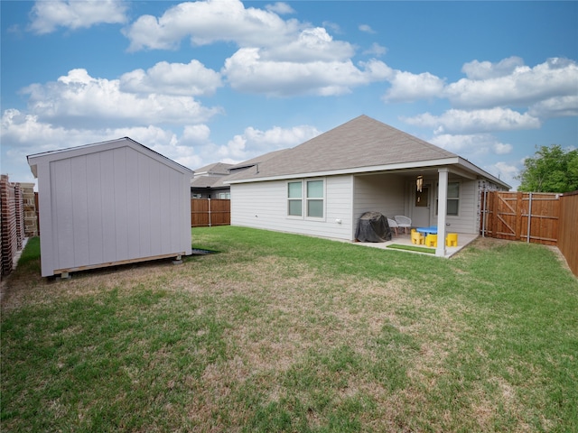 back of property with a lawn and a storage unit