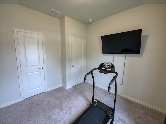 exercise area featuring light colored carpet and vaulted ceiling