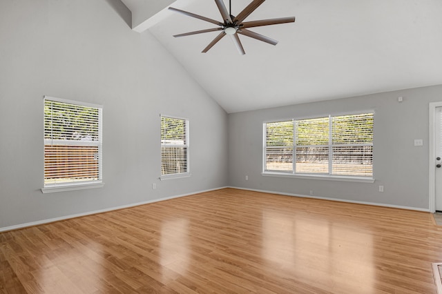 empty room featuring light wood-type flooring, beam ceiling, ceiling fan, and high vaulted ceiling