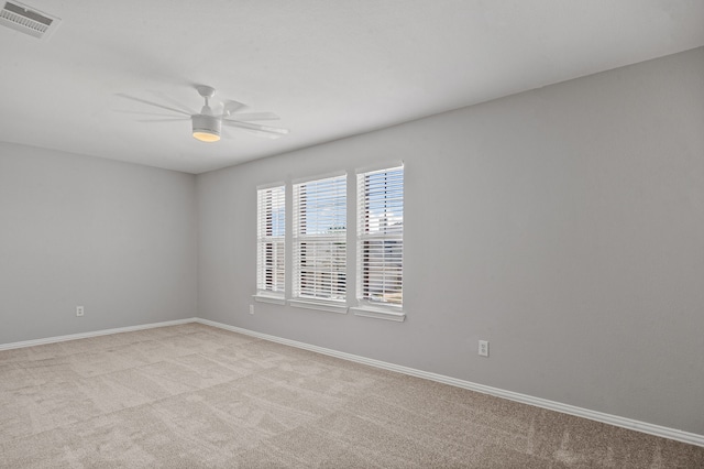 carpeted spare room with ceiling fan