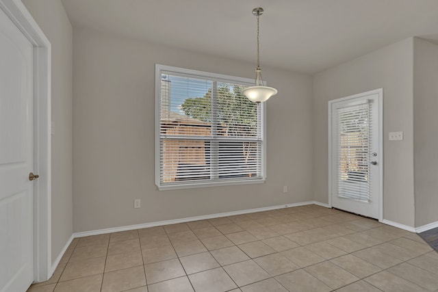 empty room with a wealth of natural light and light tile patterned floors