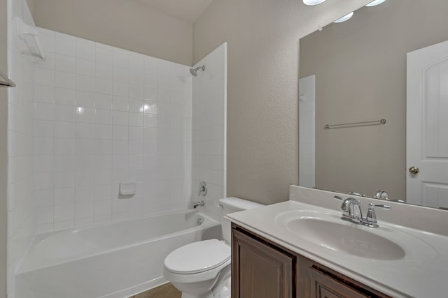 full bathroom with tiled shower / bath, vanity, and toilet