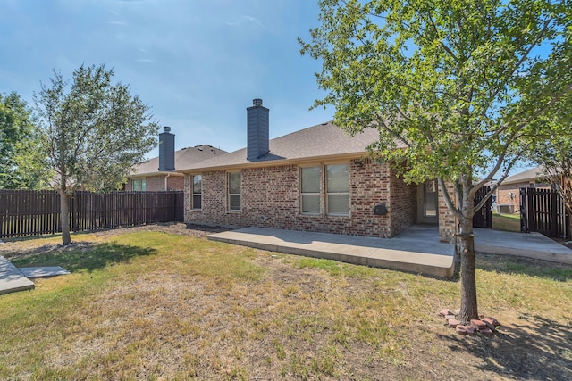 rear view of house with a lawn and a patio