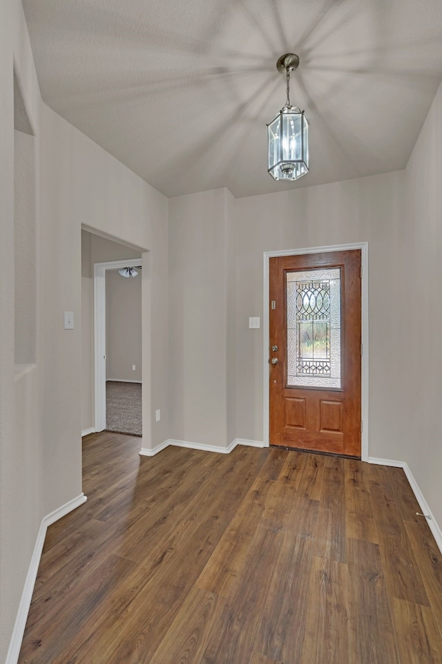 entrance foyer with a notable chandelier and dark hardwood / wood-style flooring