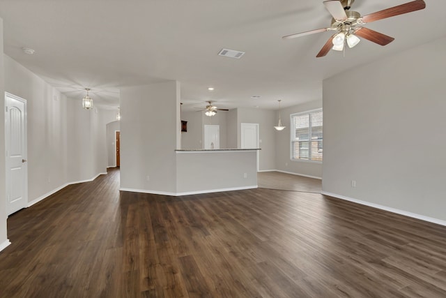 unfurnished living room with ceiling fan and dark wood-type flooring