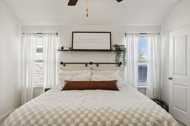 bedroom with ceiling fan, lofted ceiling, and multiple windows