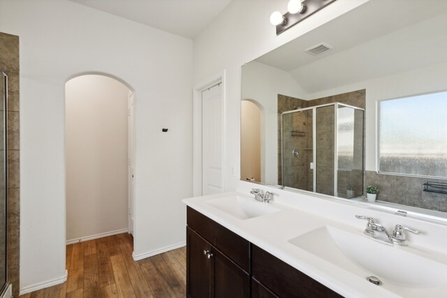 bathroom featuring vanity, lofted ceiling, a shower with shower door, and hardwood / wood-style floors