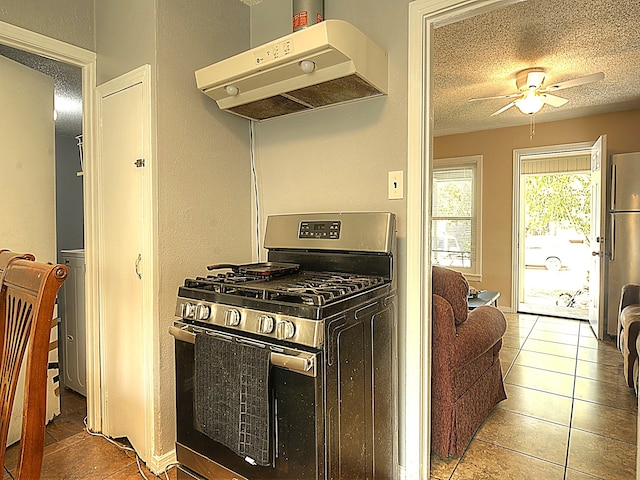 kitchen featuring ceiling fan, a textured ceiling, range hood, tile patterned floors, and stainless steel range with gas cooktop