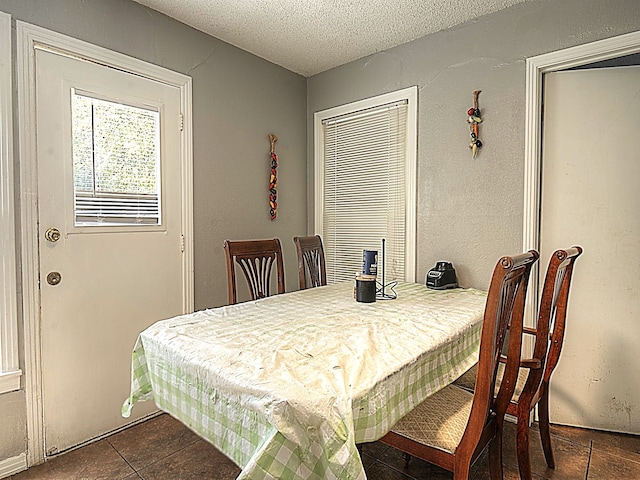 tiled dining room with a textured ceiling