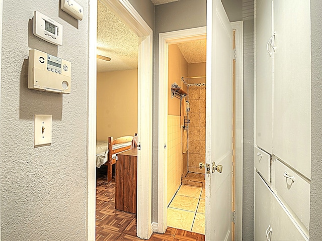 hall with a textured ceiling and dark parquet floors