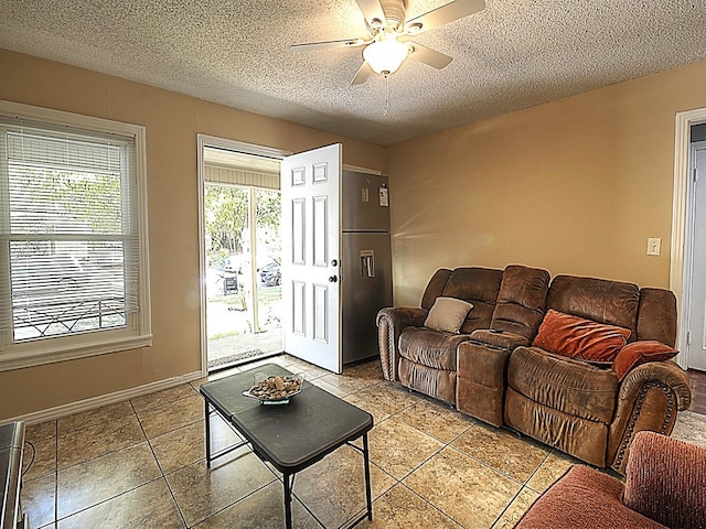 living room featuring ceiling fan and a textured ceiling