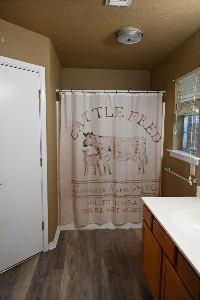 bathroom featuring a textured ceiling, wood-type flooring, vanity, and a shower with curtain